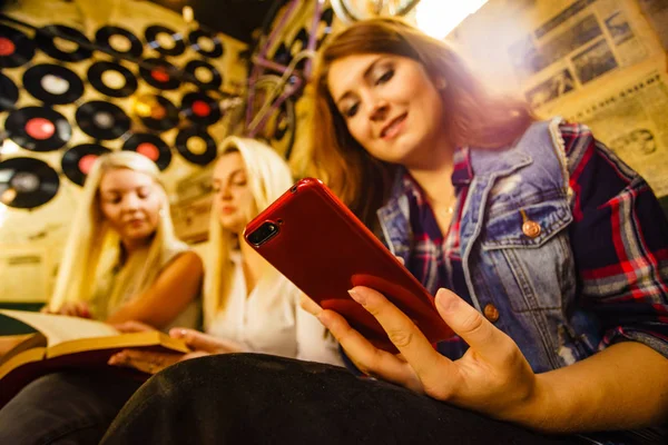 Chica en el pub usando el teléfono inteligente —  Fotos de Stock