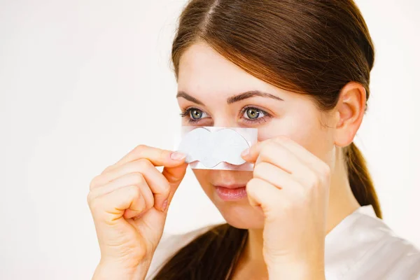 Mujer que aplica tiras de poro en la nariz — Foto de Stock