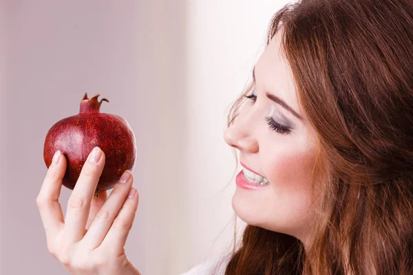 Vrolijke vrouw houdt granaatappel fruit — Stockfoto