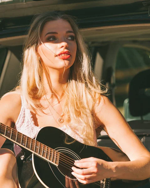Meisje met gitaar op hatchback auto — Stockfoto