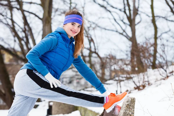 Mulher vestindo sportswear exercitando fora durante o inverno — Fotografia de Stock