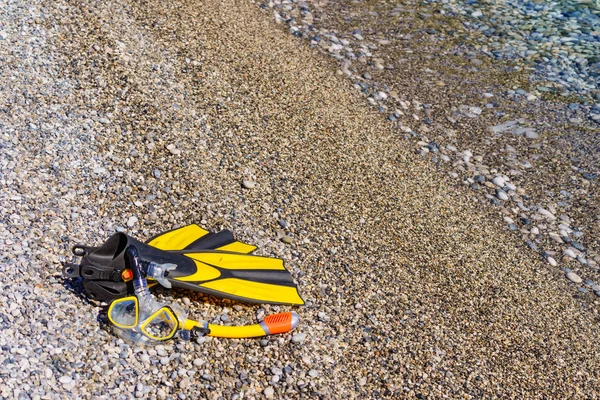 Aletas y tubo de snorkel en la orilla del mar —  Fotos de Stock