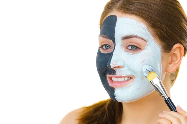 Meisje zwart masker op halve gezicht apply witte modder — Stockfoto