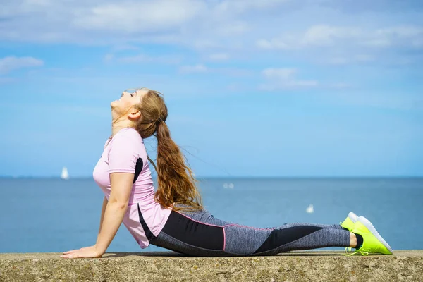 Mujer haciendo yoga junto al mar —  Fotos de Stock