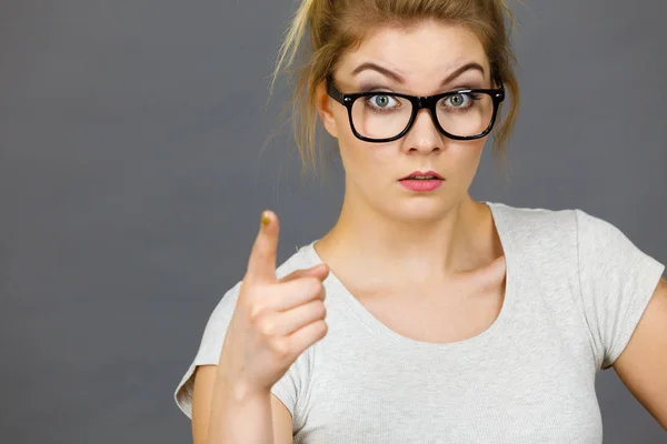 Frau mit Brille zeigt auf Kamera — Stockfoto