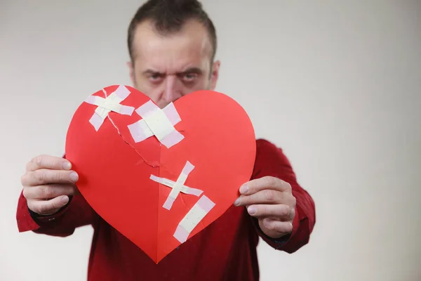 Lustiger Mann hält gebrochenes Herz — Stockfoto