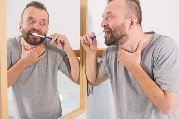 Man borstar sina tänder i badrum — Stockfoto