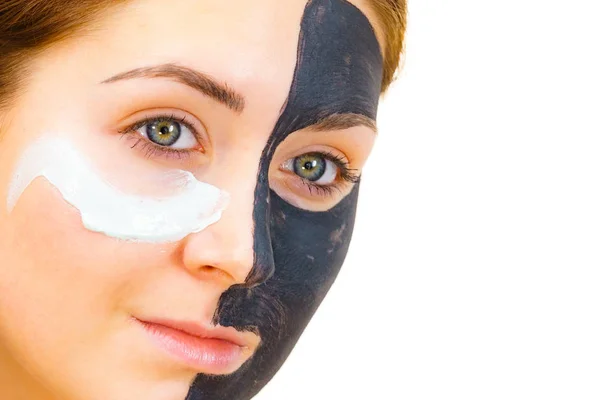 Mädchen schwarze Maske auf halbem Gesicht weißen Schlamm auftragen — Stockfoto