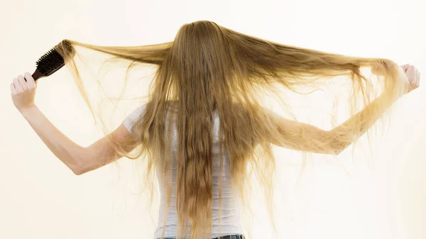 Menina loira escovando seu cabelo longo — Fotografia de Stock