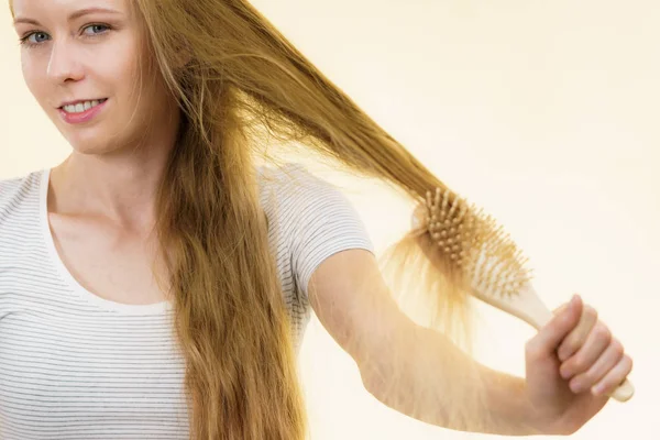 Blondynka dziewczyna szczotkowanie jej długie włosy — Zdjęcie stockowe