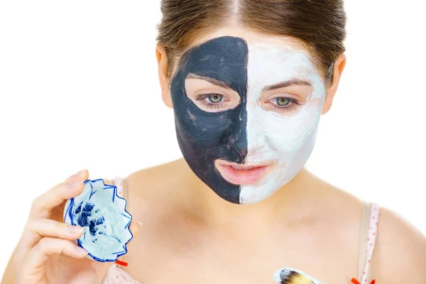 Meisje zwart masker op halve gezicht apply witte modder — Stockfoto