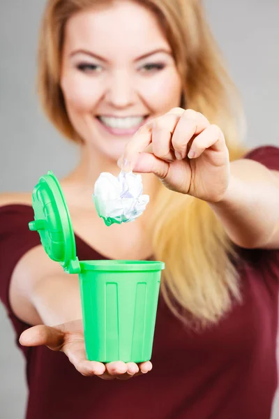 Woman putting paper into small trash can — Stock Photo, Image