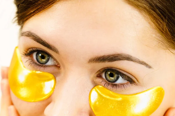 Woman with gold patches under eyes