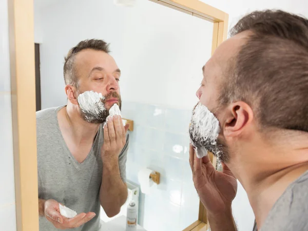 Homem aplicando creme de barbear na barba — Fotografia de Stock