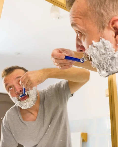 Kille rakar skägget i badrum — Stockfoto
