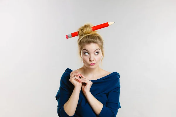 Pensando donna bionda avendo grande matita nei capelli — Foto Stock