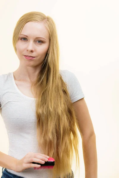 Blond flicka borsta hennes långa hår — Stockfoto