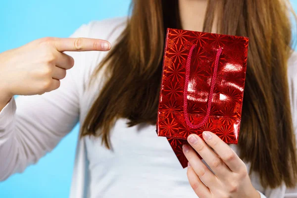 Mulher detém saco de presente vermelho nas mãos — Fotografia de Stock