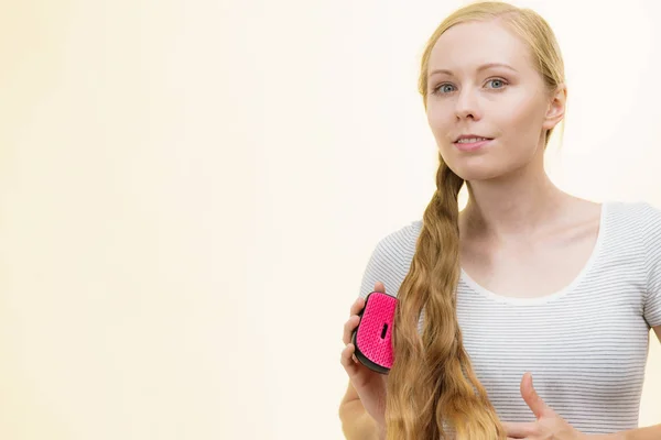 Blondýny dívka kartáčování její dlouhé vlasy — Stock fotografie