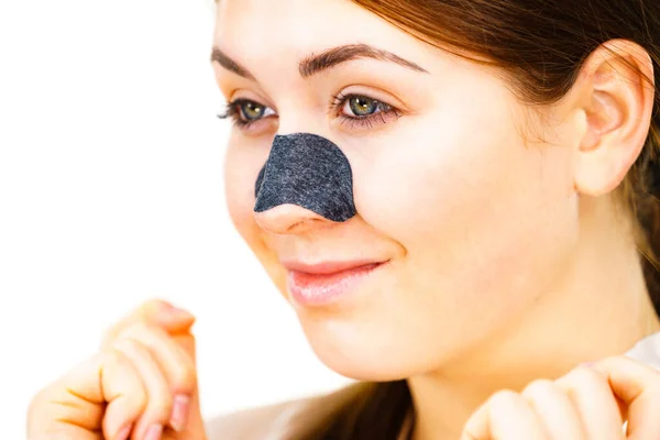 Mulher aplicando tiras de poros no nariz — Fotografia de Stock