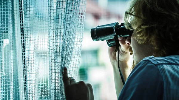 Man with binoculars spying on neighbors — Stock Photo, Image