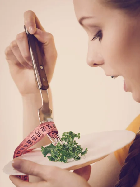 Woman on diet holding plate with lettuce — Stock Photo, Image