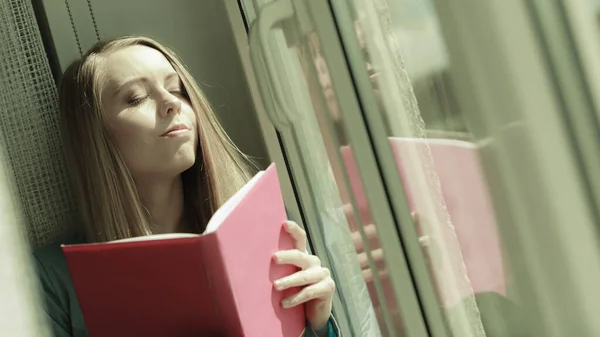 Woman reading on windowsill — Stock Photo, Image