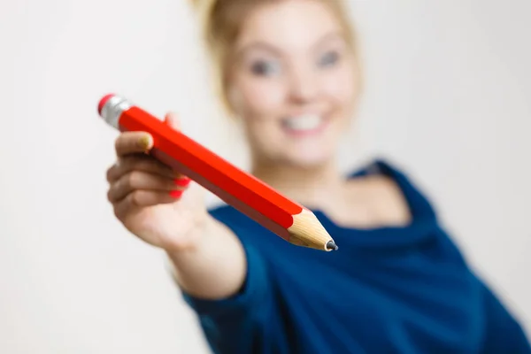 Mujer feliz sosteniendo dando lápiz grande — Foto de Stock