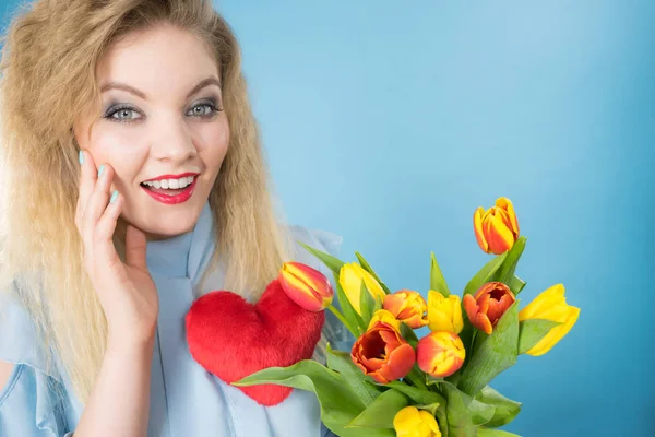 Mujer sostiene tulipanes y corazón rojo — Foto de Stock