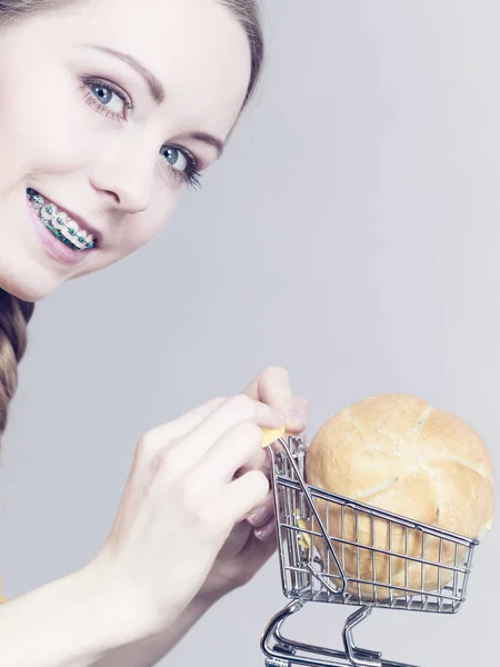 Mulher segurando carrinho de compras com pão — Fotografia de Stock