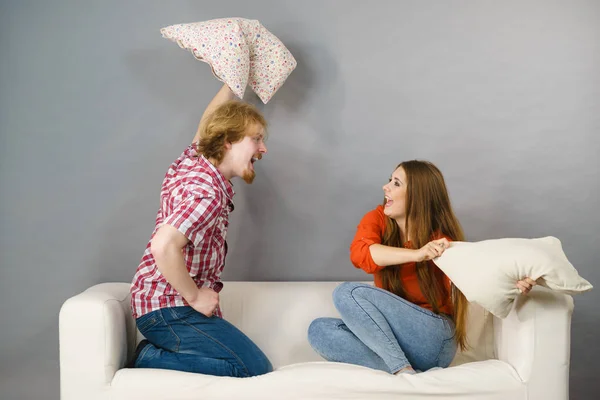 Mann und Frau liefern sich Kissenschlacht — Stockfoto