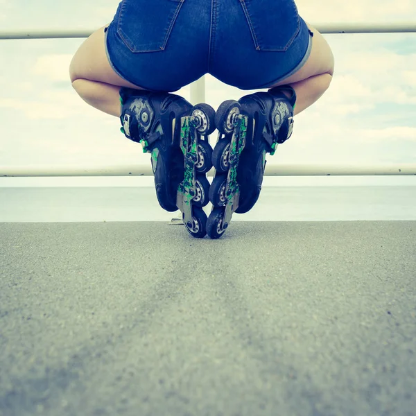 Vue de dos femme portant des patins à roulettes et des shorts — Photo