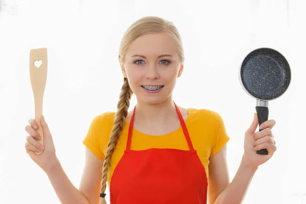 Woman holding cooking pan and spatula — Stock Photo, Image