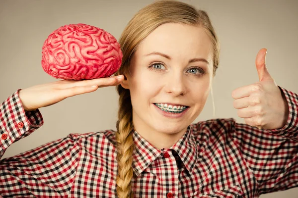 Женщина думает и держит фальшивый мозг — стоковое фото