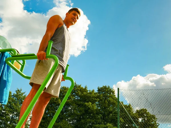 Hombre haciendo ejercicios de piernas en el gimnasio al aire libre — Foto de Stock