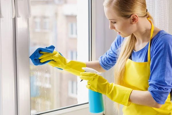 Женщина моет окно дома — стоковое фото