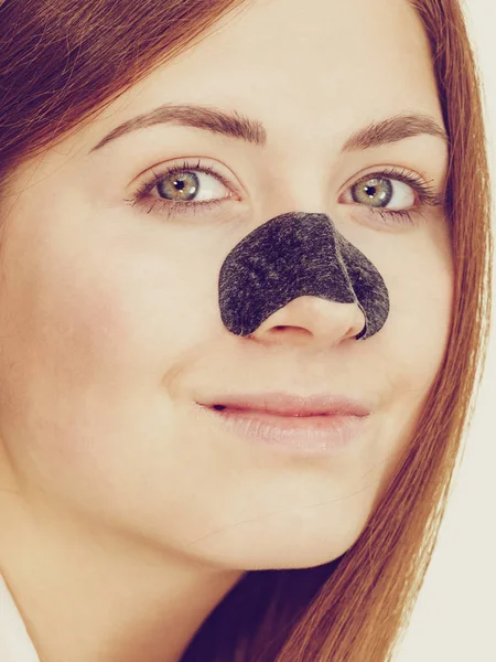 Kvinna ansöker por remsor på näsan — Stockfoto
