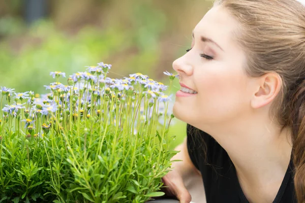 Vrouw ruikende bloemen — Stockfoto