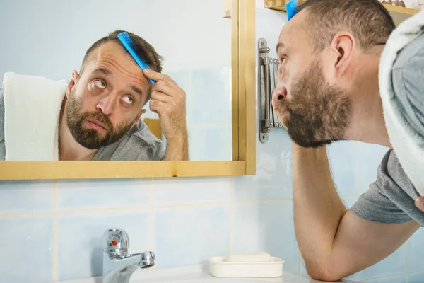 Homme utilisant peigne dans la salle de bain — Photo