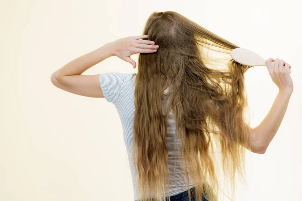 Blond meisje borstelen haar lange haar — Stockfoto