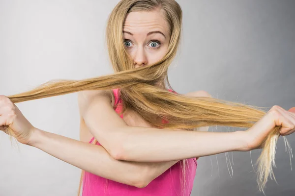 Mulher tendo rosto coberto com seu cabelo loiro — Fotografia de Stock