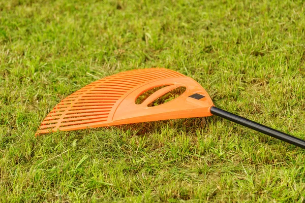 Rastrillo naranja en palo recoger hierba, herramientas de jardín —  Fotos de Stock