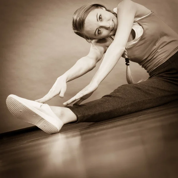 Woman in sportswear stretching legs — Stock Photo, Image