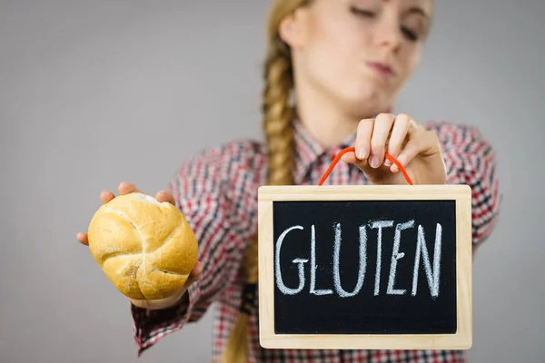 Mulher segurando placa com sinal de glúten e pão de pão — Fotografia de Stock