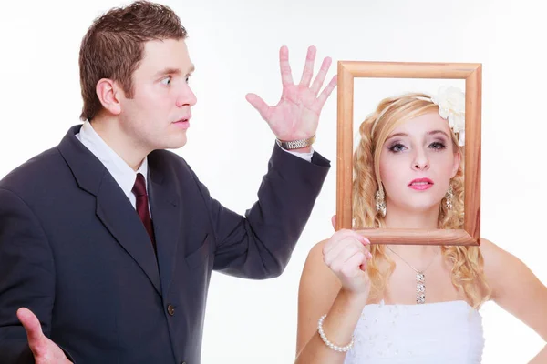 Angry groom and bride holding empty frame Stock Image