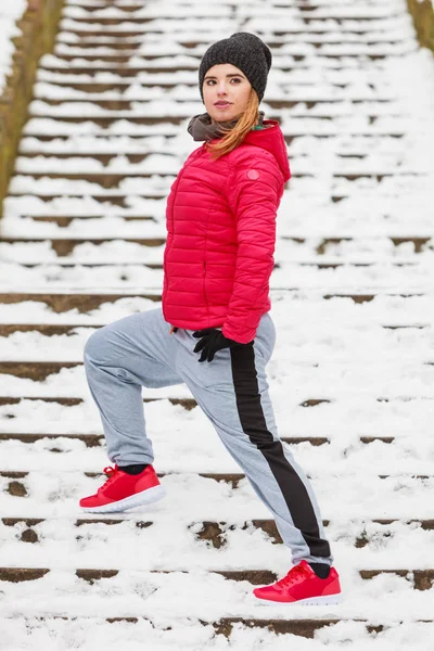 Mujer con ropa deportiva ejercitándose al aire libre durante el invierno — Foto de Stock