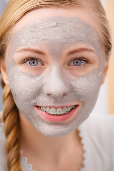 Vrouw met klei modder masker op haar gezicht — Stockfoto