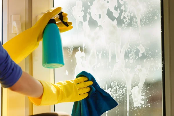 Hand cleaning window at home using detergent rag