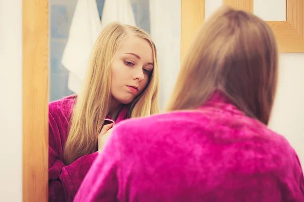 Frau betrachtet ihr Spiegelbild im Spiegel — Stockfoto