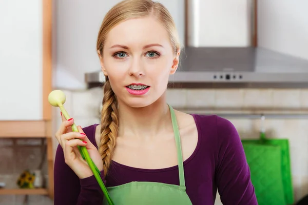 Mulher na cozinha detém cebolinha fresca verde — Fotografia de Stock